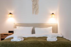 a bedroom with a bed with towels on it at Asini deluxe suite 2, with rooftop terrace and breathtaking views in Asíni