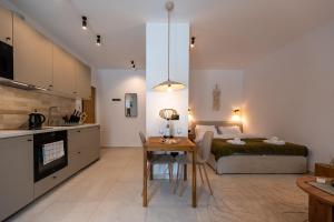a kitchen and a bedroom with a bed and a table at Asini deluxe suite 2, with rooftop terrace and breathtaking views in Asíni