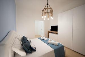 a bedroom with a bed and a chandelier at Deledda Rooms Boutique in Budoni