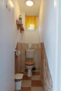 a small bathroom with a toilet and a window at János Nyaraló in Balatonmáriafürdő +31 photos