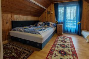 a bedroom with a bed in a room with wooden walls at János Nyaraló in Balatonmáriafürdő