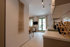 a kitchen with a counter and a living room at Asini deluxe suite 2, with rooftop terrace and breathtaking views in Asíni