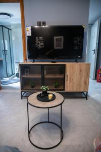 a living room with a table and a large tv at Rooftop View Chios in Chios +23 photos