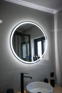 a bathroom with a round mirror and a sink at Rooftop View Chios in Chios