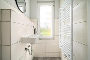 a white bathroom with a sink and a window at Ferienhaus Alt-Gaarz in Lärz +42 photos