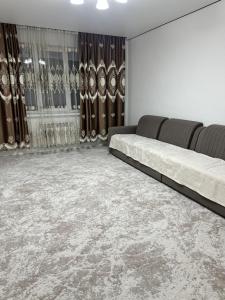 a living room with two beds and curtains at 7 Su Nury in Almaty
