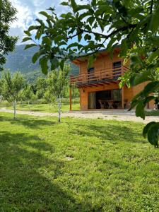 a wooden house with a grassy yard in front of it at Vikendica Diva in Varvara