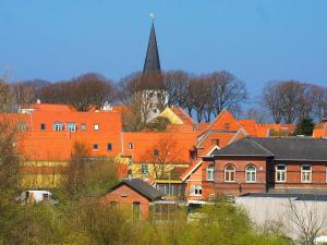 a group of buildings with a church with a steeple at Bogense Ferieboliger 500 m til kysten in Bogense +111 photos
