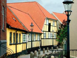 a row of houses with orange roofs and a street light at Bogense Ferieboliger 500 m til kysten in Bogense