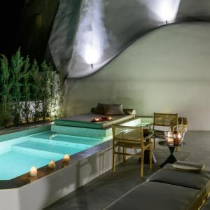 a pool in a room with a couch and a table at Avelora Suites in Pyrgos