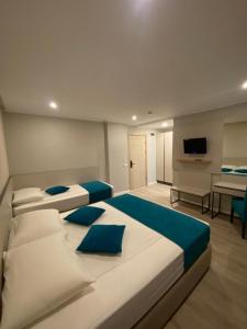ein Schlafzimmer mit zwei Betten und ein Wohnzimmer in der Unterkunft Hotel Rhodos in Eforie Nord