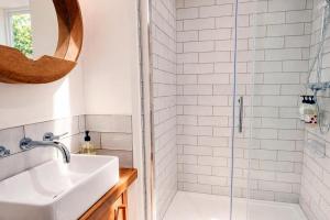 a bathroom with a sink and a shower at Bakers Yard Cottage, Bonsall, Peak District in Bonsall