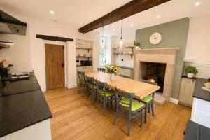 a kitchen and dining room with a wooden table and chairs at Bakers Yard Cottage, Bonsall, Peak District in Bonsall