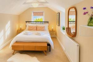 a bedroom with a large bed and a mirror at Bakers Yard Cottage, Bonsall, Peak District in Bonsall +6 photos