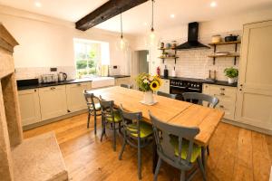 a large kitchen with a wooden table and chairs at Bakers Yard Cottage, Bonsall, Peak District in Bonsall