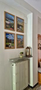 a room with a radiator and paintings on the wall at Casa Vacanza GERONIMI in San Cassiano