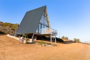 a building with a metal roof on top of a dirt field at Peace Haven @ Windfarm Accommodation in Yzerfontein