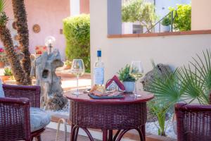 a table with two glasses and a bottle of wine at Deledda Rooms Boutique in Budoni