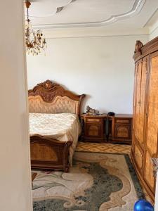 a bedroom with a bed with wooden furniture and a chandelier at holiday house in Gavarr