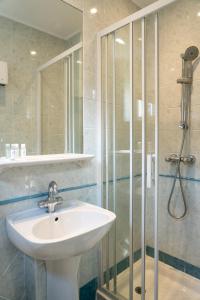 ein Badezimmer mit Waschbecken und Dusche in der Unterkunft Hotel De Monaco in Cap d'Ail