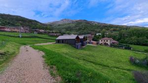 an aerial view of a farm with mountains in the background at La Finca del Valle in Valle de Vegacervera