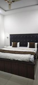 a large bed with a black headboard in a room at Hotel Ansh Palace - Village Near Taj Mahal Agra in Tājganj
