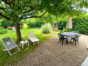 a table and chairs sitting under a tree at Chambre et salon indépendants chez l'habitant in Pierre