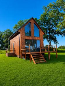 a small cabin with a large window on the grass at Domki u Gąski in Gąsiorowo Olsztyneckie
