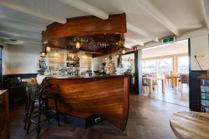 a bar in a restaurant with a wooden wall at Glamping Houseboat in Dinteloord