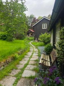 a stone path leading to a house with a bench at Lite hus i hagen in Malvik