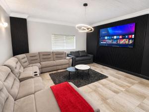 a living room with a couch and a flat screen tv at Ridgeworth Royale in Tyger Valley