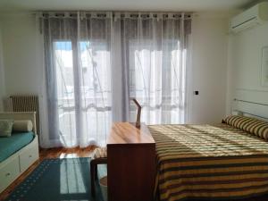 a bedroom with a bed and a large window at Alle Nuove Stelle in Udine