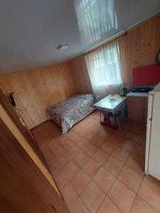 a bedroom with a bed and a table in it at Будиночок Перший rio de pulmo in Pulʼmo
