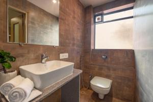 ein Badezimmer mit Waschbecken und Toilette in der Unterkunft Anthurium Hotel in Mapusa