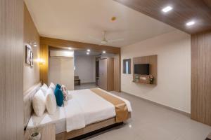 ein Hotelzimmer mit Bett und Fernseher in der Unterkunft Anthurium Hotel in Mapusa