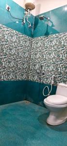 a bathroom with a toilet and a blue wall at Hotel Siddhant in Pithorāgarh