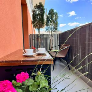 a wooden table on a balcony with two coffee cups at Apartment Chrzanòw in Chrzanów