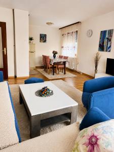a living room with a table and blue chairs at Aura Apartment Sarajevo in Sarajevo