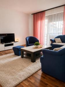 a living room with blue chairs and a coffee table at Aura Apartment Sarajevo in Sarajevo