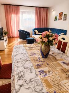 a living room with a table with a vase of flowers at Aura Apartment Sarajevo in Sarajevo