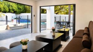 a living room with a couch and tables and sliding glass doors at Regent Heights Hotel in Johannesburg