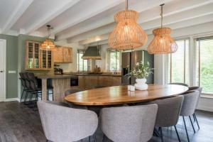 a kitchen and dining room with a wooden table and chairs at Bosch (10p) in Buren