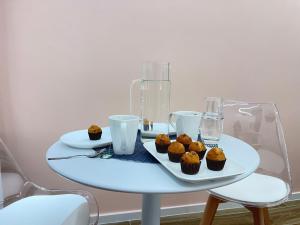 a white table with cupcakes on a plate at Alloggio degli Eroi by LocazioniOK in Mola di Bari