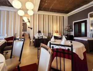 a dining room with a table and chairs in a restaurant at Logis Hôtel Le Merle Blanc in Digoin +19 photos