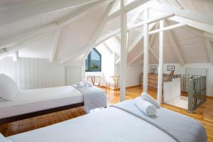 two beds in a room with white ceilings at Palairos Historic Villa in Paleros
