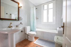 a white bathroom with a sink and a toilet at Palairos Historic Villa in Paleros +26 photos