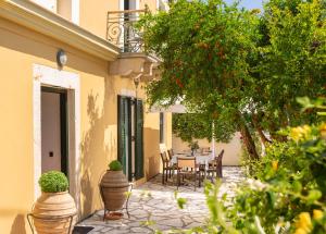a patio with a table and chairs and a tree at Palairos Historic Villa in Paleros