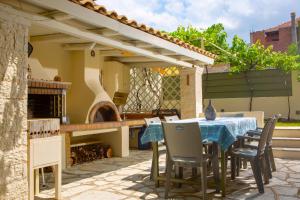 a patio with a table and chairs and a pizza oven at Palairos Historic Villa in Paleros