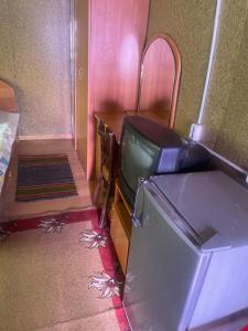 a tv in a room with a bed and a desk at Домики in Borovoye