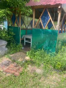 a shed with a bench in the grass at Домики in Borovoye